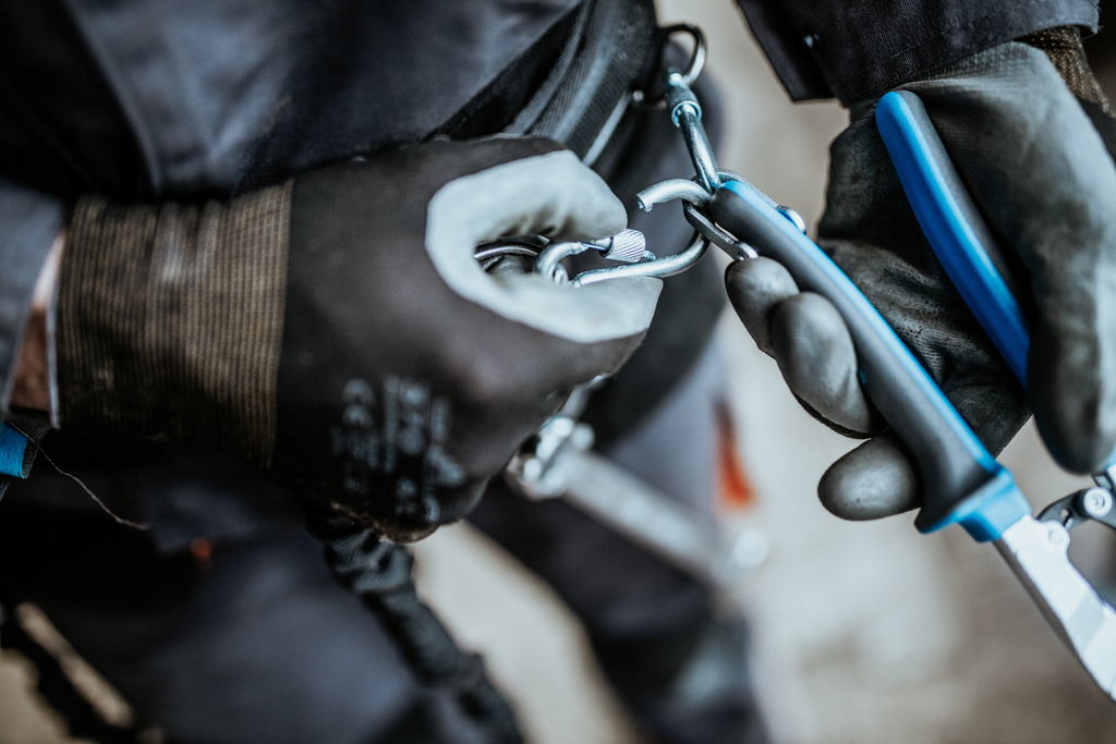 The carabiner on the lanyard is attached to the ring on the tool. The rings on the tools are large enough to accept 2 carabiners.